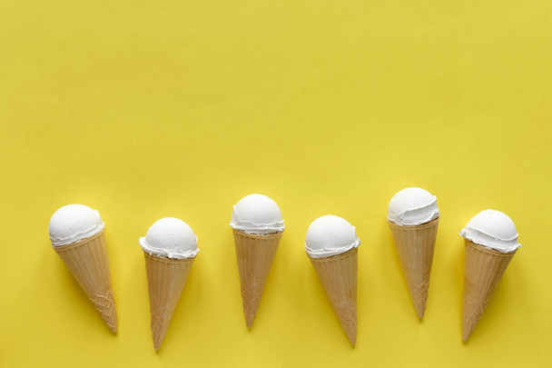 Fila de conos de helado de vainilla en amarillo
 - Foto, Imagen