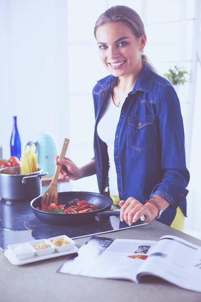 Young woman in the kitchen preparing a food - Foto, Bild