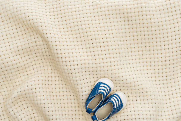 top view of blue sneakers on beige blanket with copy space  - Photo, Image