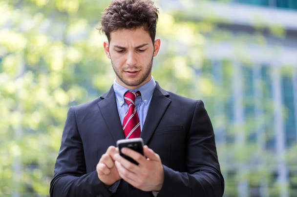 Young manager using a smartphone outdoor - Photo, Image
