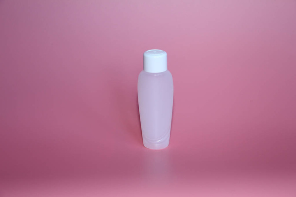 One plastic bottle on a pink background. Bottle for cosmetics. - Foto, Imagem