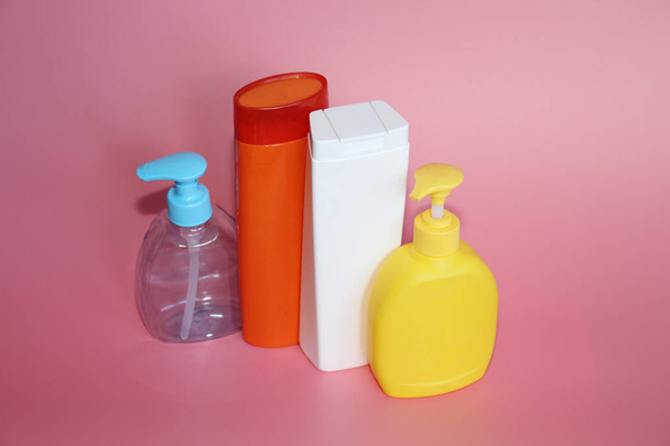 A lot of plastic bottles on a pink background. Bottles for cosmetics. - Foto, immagini