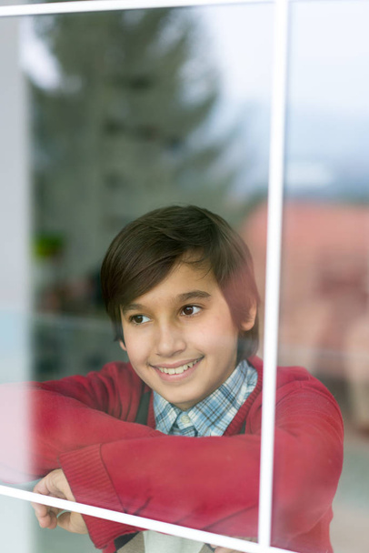 Happy boy behind window glass - Photo, Image