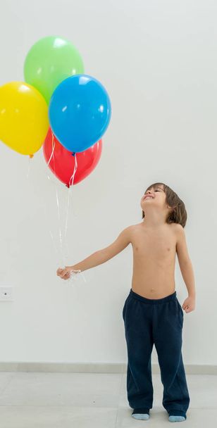 Boy enjoying a bunch of balloons  - Foto, Imagem