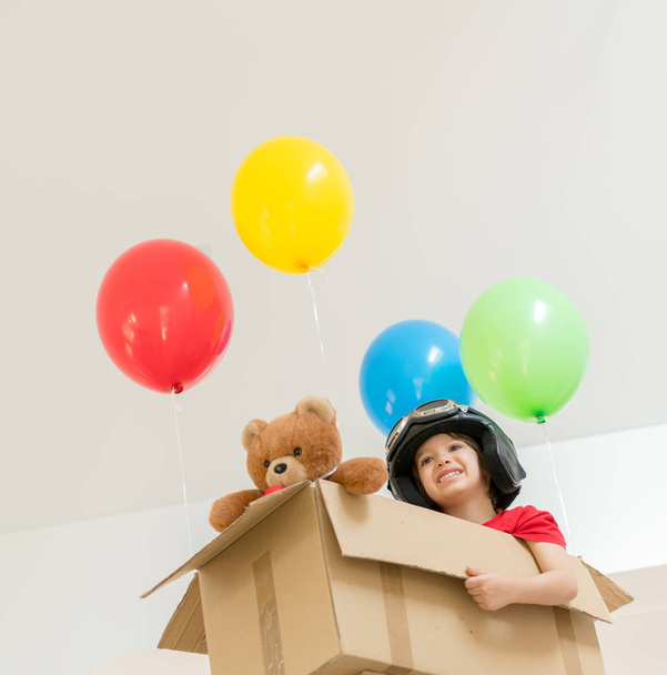 Happy boy sitting in his box imagining him self flying  - Foto, afbeelding