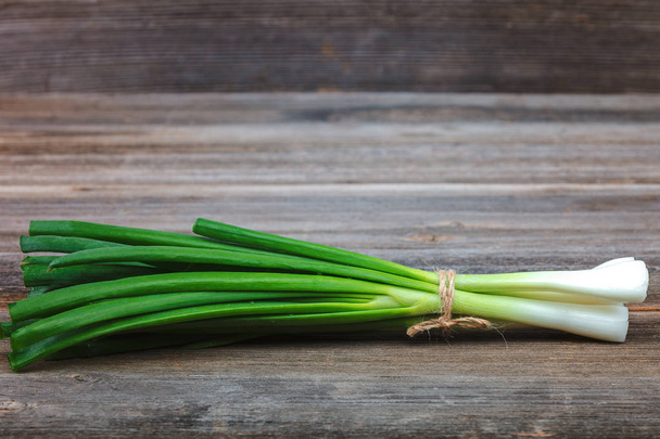 Onion green fresh on a wooden background - Foto, Imagen