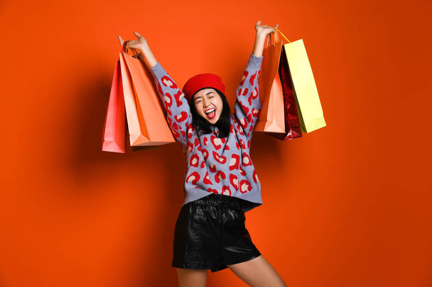 A pretty young woman stylishly dressed in a hat with bags after shopping - Foto, Imagem