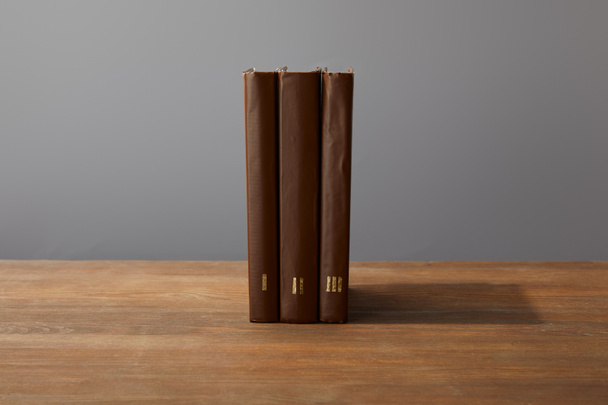 Brown books on textured wooden surface isolated on grey - Photo, Image