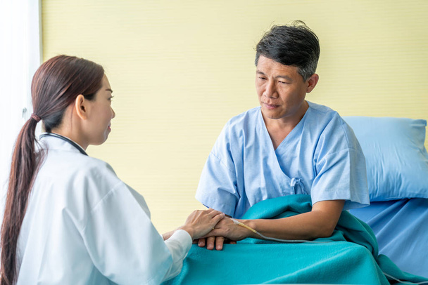 female doctor reassuring on her senior patient hand - Foto, imagen