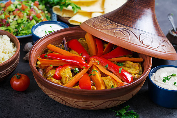 Marokkanisches Essen. traditionelle Tajine-Gerichte, Couscous und frischer Salat auf rustikalem Holztisch. Tajine Hühnerfleisch und Gemüse. Arabische Küche. - Foto, Bild