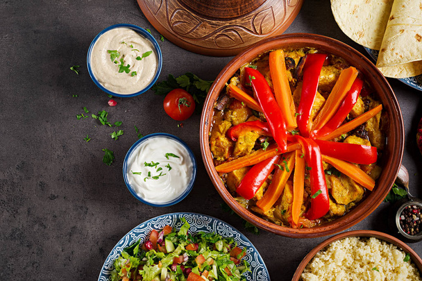 Moroccan food. Traditional tajine dishes, couscous  and fresh salad  on rustic wooden table. Tagine chicken meat and vegetables. Arabian cuisine. Top view. Flat lay - Photo, Image