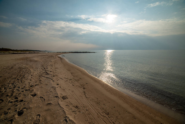 спокійний морський пляж влітку з великими скелями і дерев'яними стовпами з
  - Фото, зображення