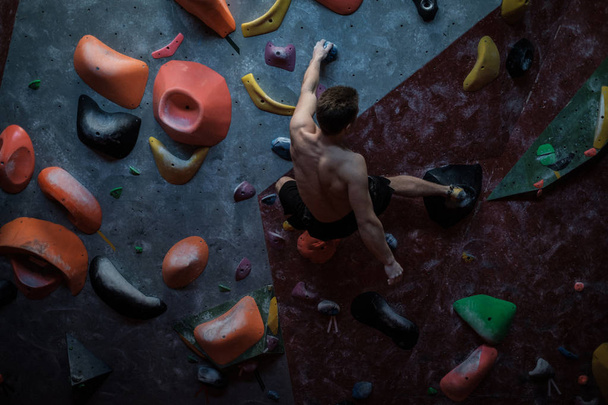 Athletic man practicing in a bouldering gym - Foto, immagini