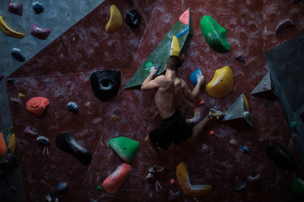 Athletic man practicing in a bouldering gym - Photo, Image