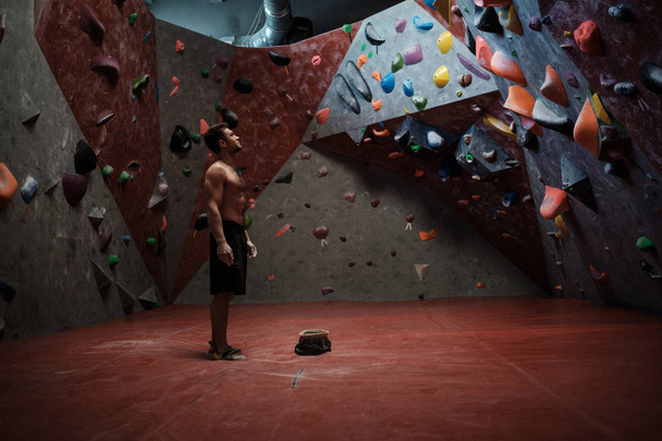 Athletic man practicing in a bouldering gym - Fotoğraf, Görsel