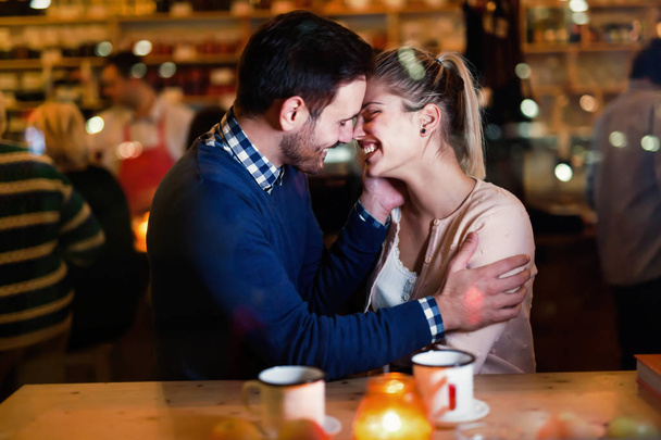 Happy couple kissing at bar and having date - Fotó, kép