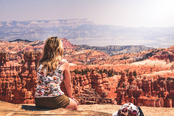 Hiker in Bryce Canyon resting enjoying view Hiking girl in beautiful nature landscape with hoodoos, spires rock formations. - Photo, Image