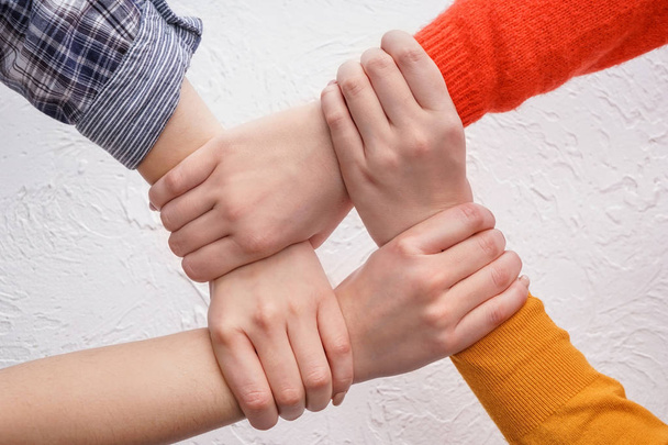 People putting hands together on light background - Photo, Image