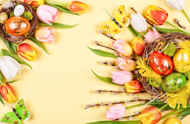Easter composition with Easter eggs in nest and  spring flowers - Foto, afbeelding