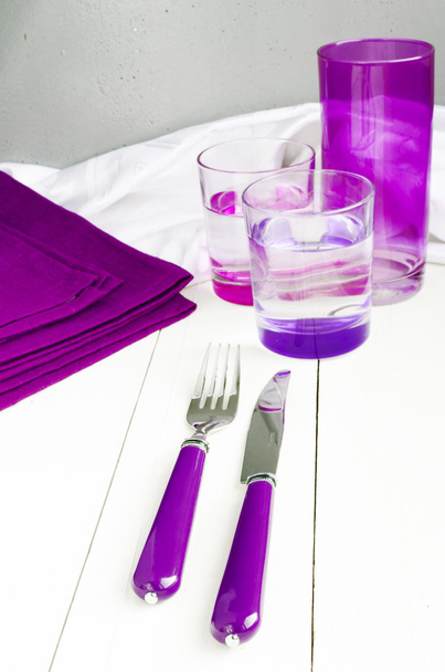 Ensemble de table de traiteur en couleur pourpre avec argenterie, serviette et lunettes dans un style vintage
. - Photo, image