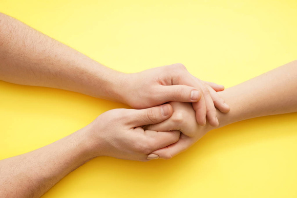 Man holding hand of young woman on color background - Photo, Image