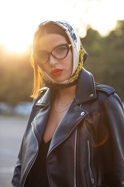 Stylish brunette model with bright makeup wearing head scarf pos - Zdjęcie, obraz