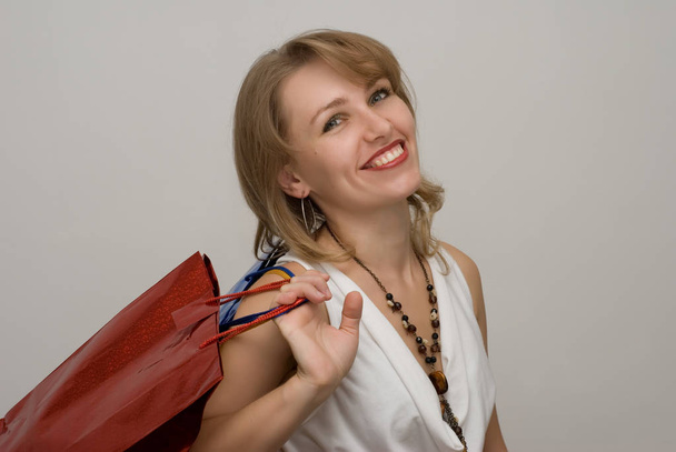 portrait of beautiful adult woman with shopping bags on white - Photo, image