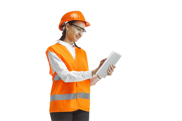 The female builder in orange helmet isolated on white - 写真・画像