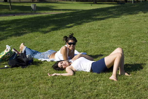 beautiful young women spending time together on green grass in park - Valokuva, kuva