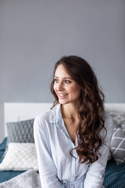 Portrait happy pretty woman on bed indoors. - Foto, Bild