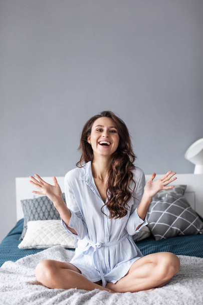 Attractive young woman smiling on the bed at home. - Foto, Imagem