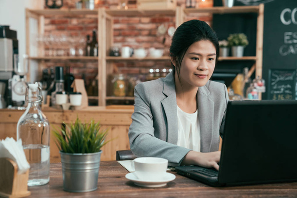 office worker typing on laptop in coffee shop - Фото, изображение