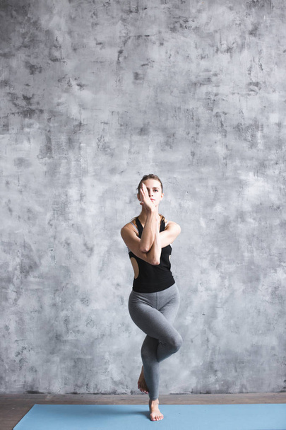 Full-length portrait of young beautiful woman doing yoga exercise indoors.  - Foto, Imagen
