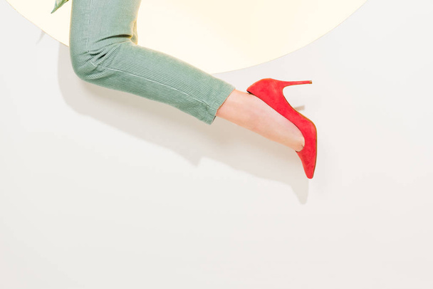 vista cortada de jovem mulher em calças elegantes e saltos altos vermelhos no branco com espaço de cópia
 - Foto, Imagem