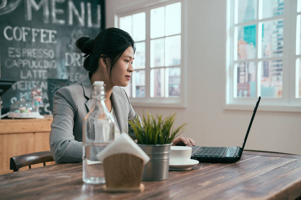 woman sitting with netbook in modern cafe bar - Фото, изображение
