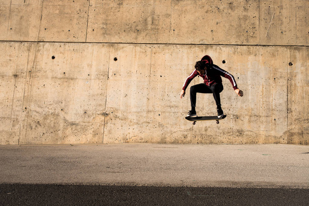 skateboarder mâle sautant sur le skateboard au lieu urbain  - Photo, image