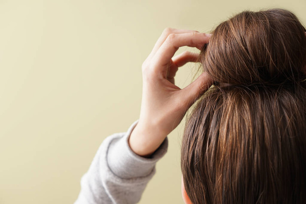 Young woman with hair bun on color background - Fotó, kép