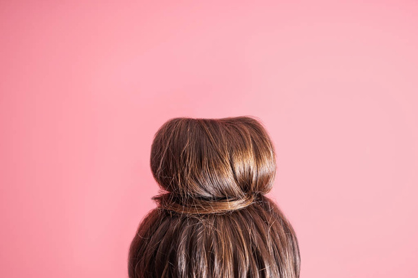 Young woman with hair bun on color background - Photo, Image