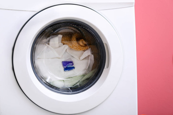 Wasmachine met Wasserij op kleur achtergrond - Foto, afbeelding