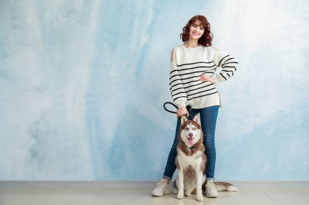 Young woman with her cute dog near color wall - Photo, Image