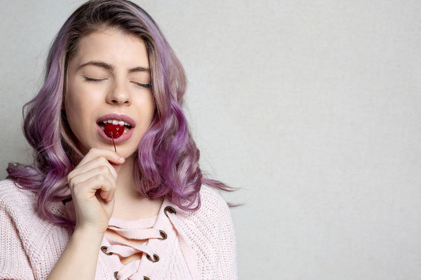 Piękna dziewczyna szczęśliwy z falisty fioletowy włosy korzystających z wiśni. Puste - Zdjęcie, obraz