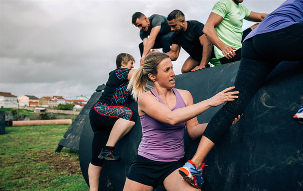 Participants in an obstacle course climbing a drum - Photo, Image