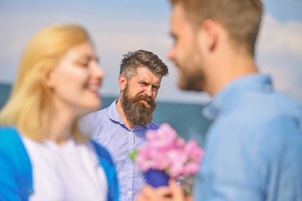 Couple in love happy dating, jealous bearded man watching wife cheating him with lover. Lovers meeting outdoor flirt romance relations. Jealous concept. Couple romantic date lovers bouquet flowers - Foto, Imagen
