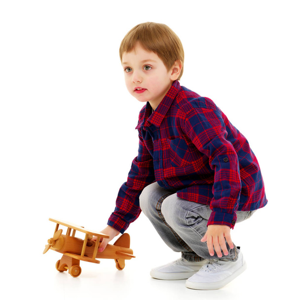 Pieni poika leikkii puinen kone - Valokuva, kuva