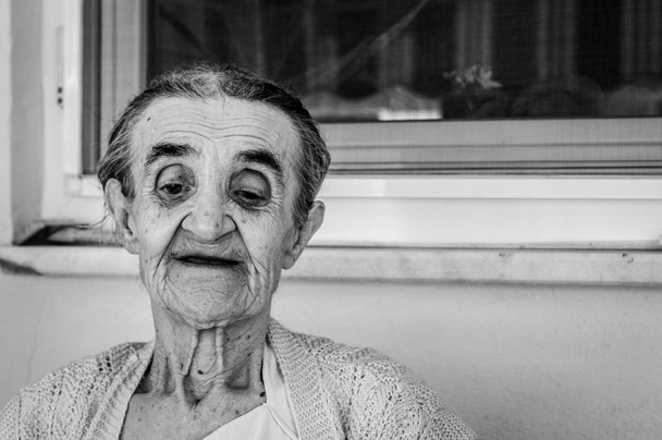 Egy nyári napon az erkélyen ülve nagyon régi idős asszony - Fotó, kép