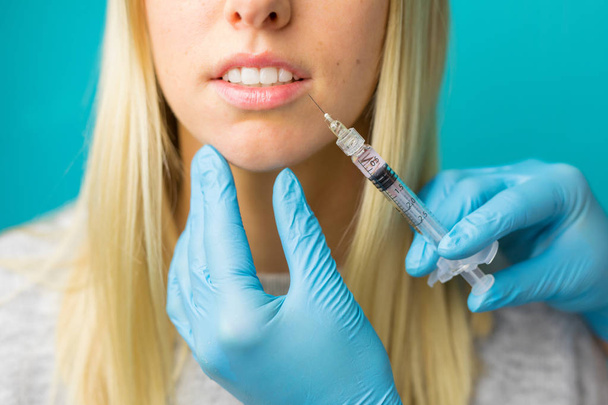 Лікар робить ін'єкції в губи жінки
 - Фото, зображення