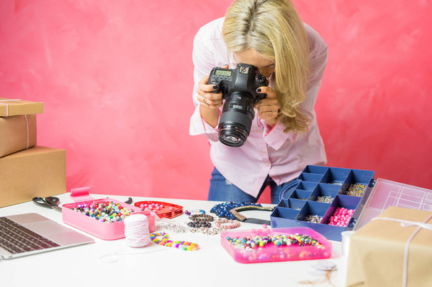 Woman taking photos of her own created merchandise, sells them online and mails packages to buyers. - Photo, Image