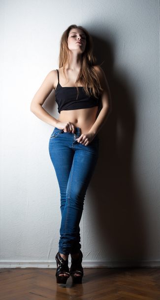 Image of sensual slim woman taking off jeans - Photo, Image