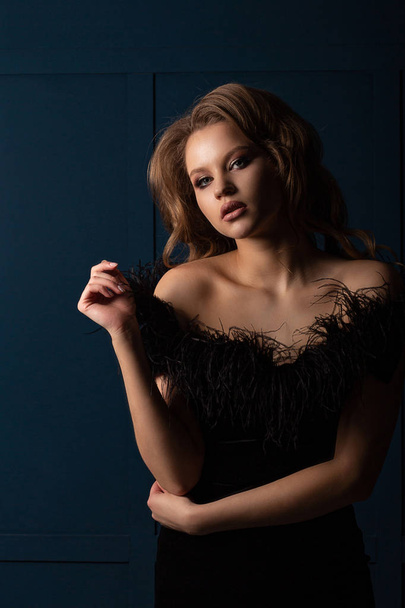 Magnificent blonde girl wearing black dress with naked shoulders - Фото, изображение