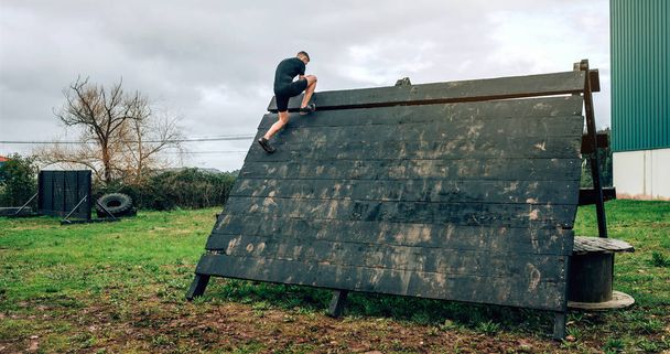 Participante en carrera de obstáculos escalada pirámide obstáculo
 - Foto, imagen